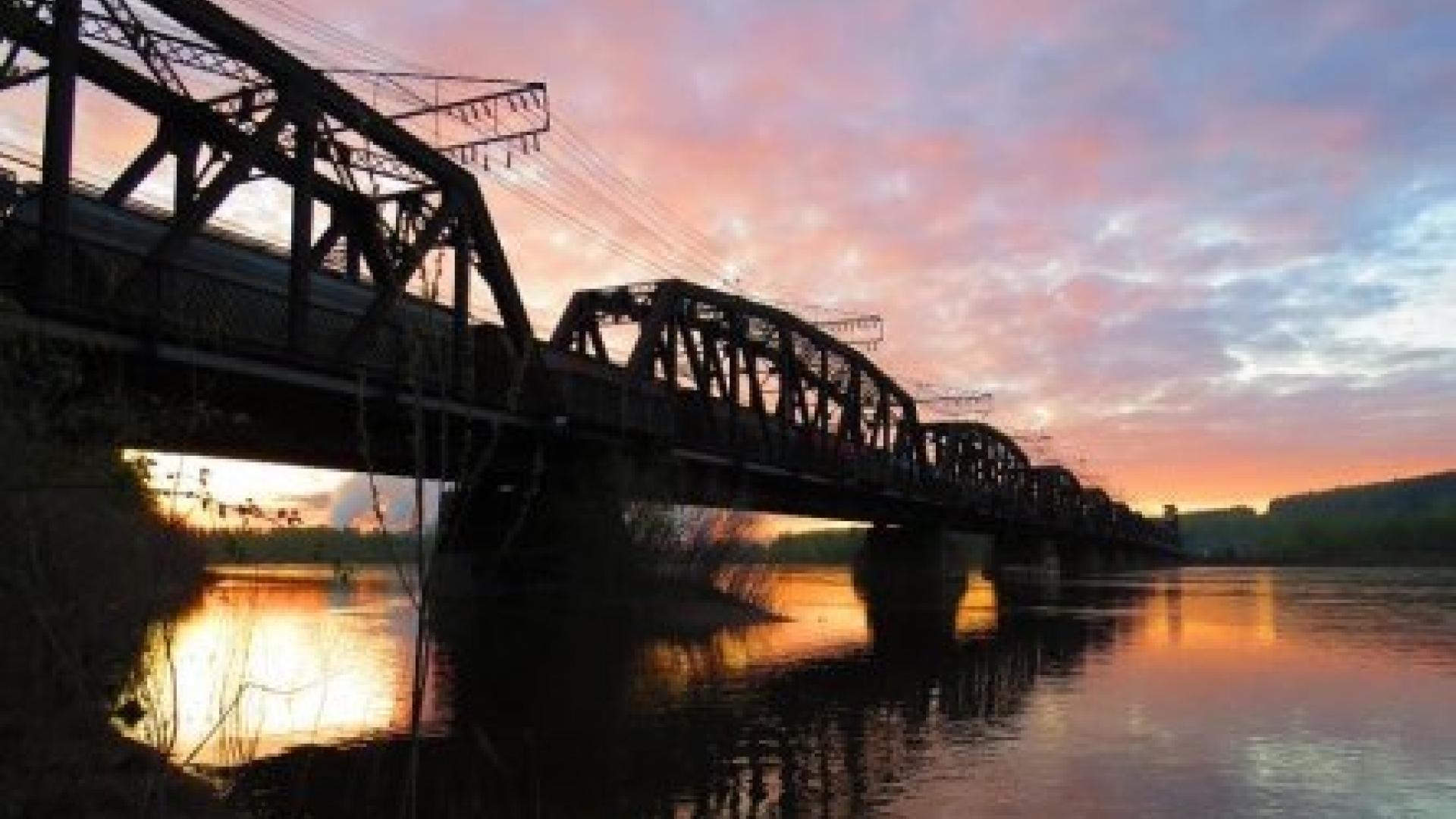 sunset photograph of the CN bridge crossing the Nechako river. Credit source Chuck Chin. 
