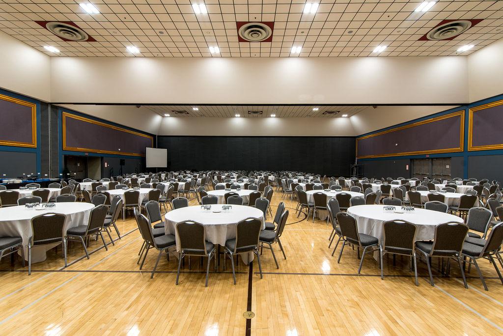 Prince George Conference and Civic Centre auditorium, with tables and chairs set for a lunch banquet.